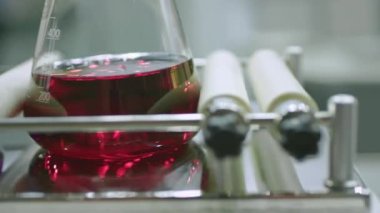 Kimya laboratuvarında çalışan genç bir kimya mühendisi. Laboratuvar Karıştırıcı. Kimyager bir deneyde laboratuvar karıştırıcısı ve karıştırıcı ile çalışıyor.