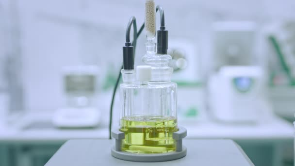 Μαγνητικός αναδευτήρας με ταχύτατα κινούμενη μπάρα ανάδευσης για ανάμιξη υγρού στο εργαστήριο φαρμακευτικής, ιατρική έκθεση: close up, super slow motion. Χημεία, επιστήμη, φαρμακευτική, εργαστηριακός εξοπλισμός — Αρχείο Βίντεο