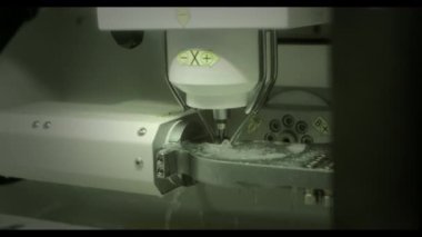 Profesyonel CNC diş değirmeni makinesi. Diş laboratuarında yapay diş şekilleri oyuyor. Klinikteki diş teknisyenleri tarafından yapılan yapay dişlerden biri..