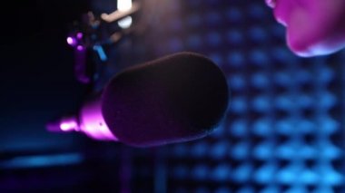 Güzel genç kız DJ mikrofona konuşuyor, podcast 'i kaydediyor ya da radyo için sabah haberlerini sunuyor. Podcast sunucusunun ya da DJ 'in mikrofondaki konuşmasını kapat. Profesyonel kulaklık takıyor..
