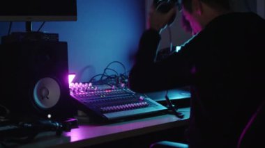Profesyonel bir DJ ya da kulaklıklı bir prodüktör stüdyoda miksaj konsolunun arkasında müzik yaratır. Dans ediyor, kollarını sallıyor. Sanatçı yaratıcılık yapar. Yeni bir parça kaydedildi.