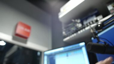 Radyo stüdyosunda mikrofon. DJ mikrofonu hareket ettirir ve sıcak haberleri yayınlamaya başlar. Akşam podcasının kayıtları. Kayıt stüdyosunda ekipman