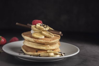 Krep çilek, ahududu, muz ve çikolata beyaz tabakta. Yatay. Boşaltmak
