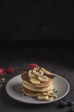 Krep çilek, ahududu, muz, çikolata ve krema beyaz tabakta. Dikey. Boşaltmak