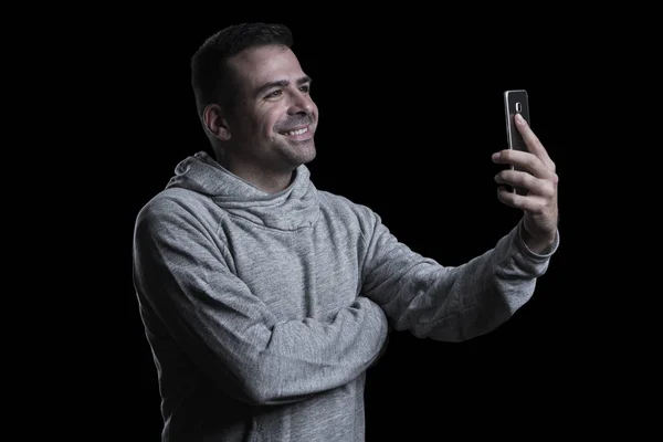 Portrait d'un homme prenant un selfie. Fond noir. Horizontal . — Photo