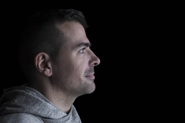 Yana bakan bir adamın portresi. Siyah arka plan. Yatay. Copyspace.