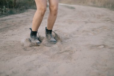 Dişi bacakları çölde atlıyor toz bulutları taşıyarak.