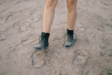 Dişi bacakları çölde atlıyor toz bulutları taşıyarak.