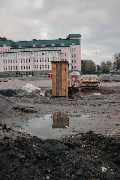 typical ukrainian street toilet on the background of an expensive building pink color