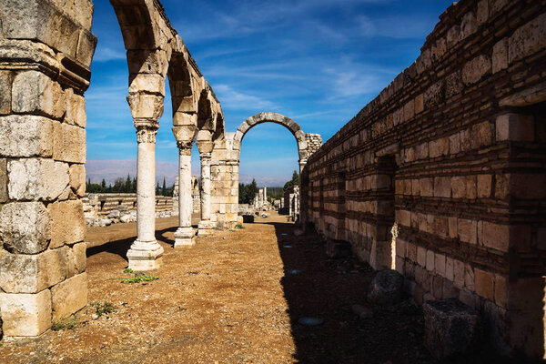 Archway in Umayyad city ruins in Anjar with mountains, Bekaa valley, Lebanon