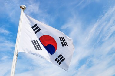 Rüzgar hafif beyaz bulutlar ile mavi gökyüzü ile Kore bayrağı