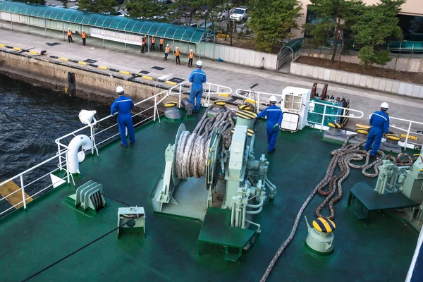 Docking with the ferry from Jeju at Mokpo harbor with orange and blue clothed workers, Mokpo, South Korea — Stock Photo, Image