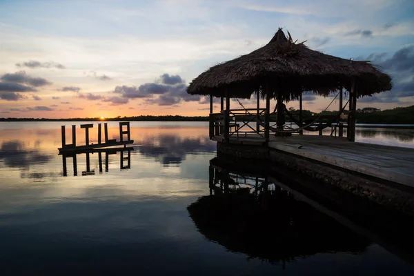 Солнце садится в лагуне позади знака Утила, Утила, Гондурас, Центральная Америка — стоковое фото