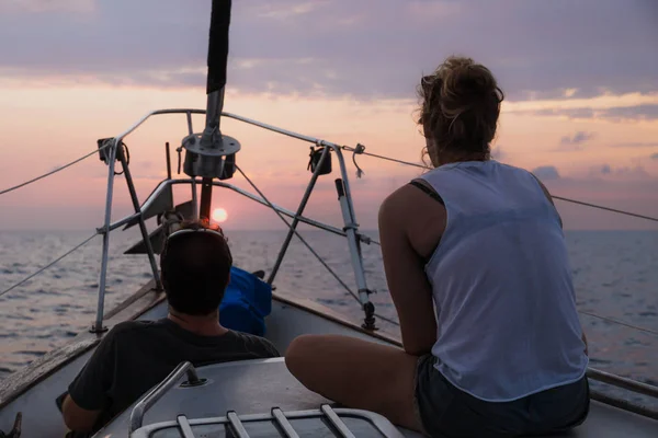 Man and woman enjoying sunset on the front of a sailboat in Honduras, Central America — Stock Photo, Image