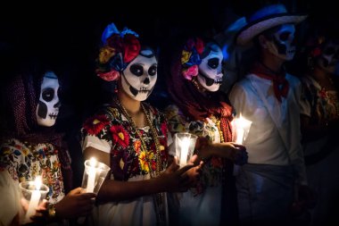 Merida, Cementerio genel, Meksika - 31 Ekim 2018: Catrina customes ile üç kadın ve erkek ile beyaz kovboy elbise ile kafatası makyaj holding candels dia de los muertos Festival Des Las Animas, geçit töreninde