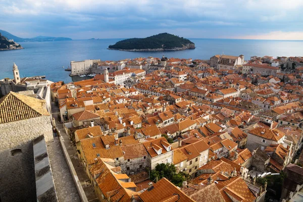 Panorama view of the mediterranean old town of Dubrovnik with orange tiled roofs and walkway on the fortress wall, Croatia