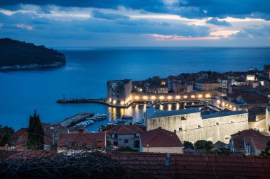 Dubrovnik Hava gece görünümü ışıklı kale duvarı ve dramatik cennet, Hırvatistan ile güneş battıktan sonra Harbor