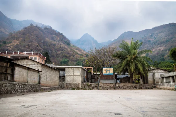 Campo de basquete no vale da aldeia Jaibalito ao longo do lago Atitlan com montanhas enevoadas, Guatemala — Fotografia de Stock