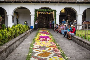 Alfombre, kilise arka bahçesinde ve yerel insanlarla birlikte oturan Semana Santa için çiçek halı, Santiago Atitlan, Guatemala
