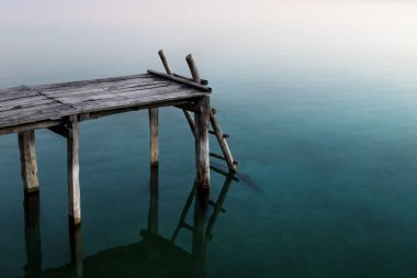 Gölde gün batımı renk yansımaları ile merdiven ile İskele, El Remate, Peten, Guatemala
