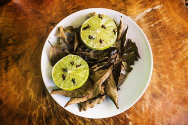 Ahşap masada kireç, karanfil ve defne ile doğal kovucu plaka