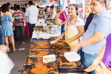 Borular, muz yapraklarına sarılı geleneksel tavuk yemeği Merida, Yucatan, Meksika 'daki San Sebastian Park' ta ölüler günü için satılıyor.