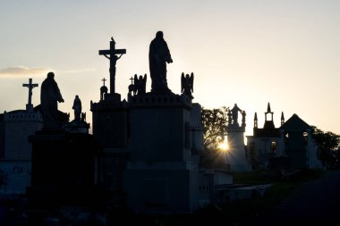 Cementerio General 'de gün batımında mezarların arka ışıkları ve siluetleriyle, Merida, Meksika
