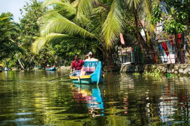 Turist Kerala 'nın durgun sularında yerel bir adamla Alleppey, Alappuzha, Hindistan' a gidiyor.