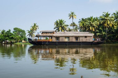 Kerala 'da geleneksel yüzen ev teknesi Palmiye ağacı kıyısı boyunca Alappuzha, Alleppey, Hindistan