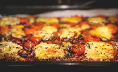 Taze mozzarella, domates, kırmızı soğan ve fırında pişirilmiş kekikli pizza.