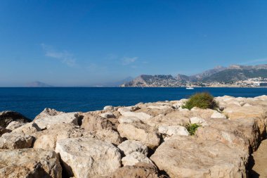Kıyı yolu koyu mavi okyanus boyunca Calpe, Costa Blanca, İspanya 'da şehir ve kayalık uçurumlar manzaralı