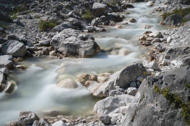 Hareket, güneşli Alp manzarası, Mieming, Tirol, Avusturya 'da berrak ve taze bir dağ nehri bulanıklaştırdı.
