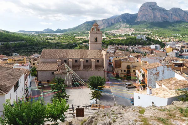 Church and main square of Polop de Marina with rocky mountainrange, Costa Blanca, Spain