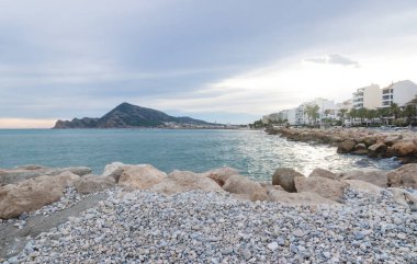 Altea kıyı şeridi boyunca gün batımı dağ ve okyanus manzaralı taş plajlı, Altea, Costa Blanca, İspanya