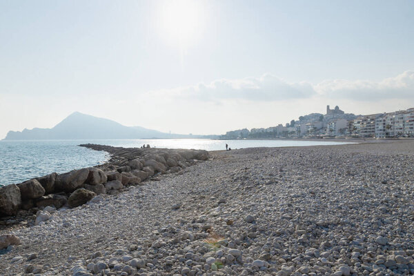 Panorama view of stone beach with view on sunny Altea city coastline, Costa Blanca, Spain