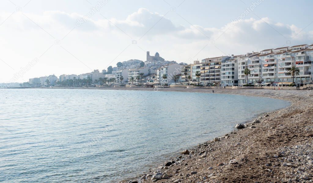 Stone beach with view on sunny Altea city coastline with hill and church, Costa Blanca, Spain