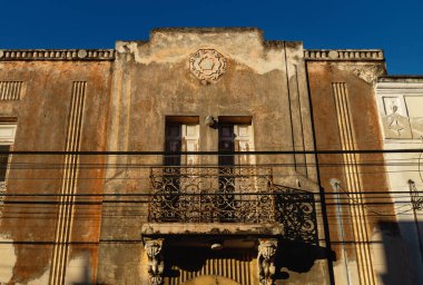 Alçılı ve balkonlu terk edilmiş koloni evi cephesi güneş, Merida, Yucatan, Meksika