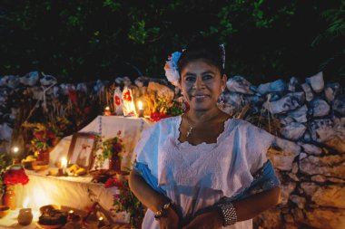Merida, Meksika - 31 Ekim 2018: Geleneksel giysili Meksikalı kadın sunağın önünde ölü 'dia de los muertos', Merida, Yucatan, Meksika