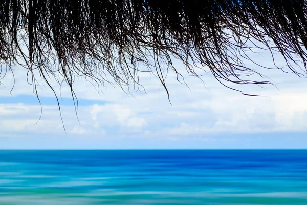 View from restaurant to beach with tropical sea and sky. Tropical concept. Vacation concept background. Motion blur sea water.