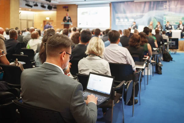 Man with laptop on large business presentation