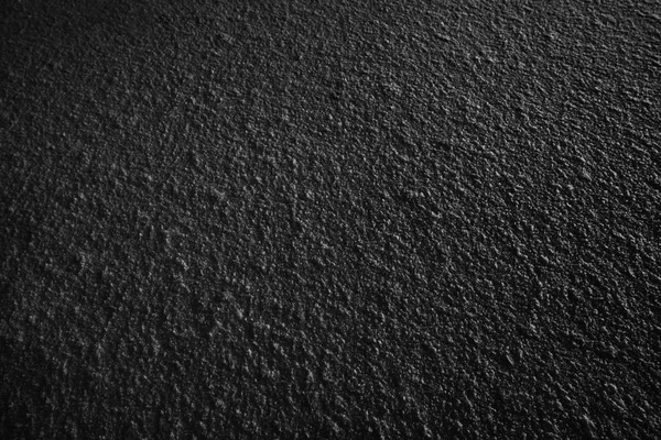 dark black surface of the snow or plastered wall, dark background of fresh snow texture in black and white