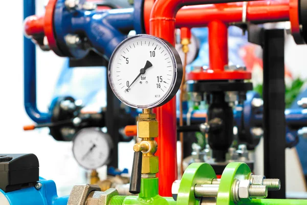 The equipment of the boiler-house, - valves, tubes, pressure gauges, thermometer. Close up of manometer, pipe, flow meter, water pumps and valves of heating system in a boiler room.