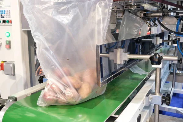 Food factory automated robotic machine. Conveyor product line for cooking and packing rations and food packs. packing potatoes in a plastic bag