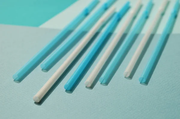 Beyaz ve mavi plastik tüpler, turkuaz renk. Seçici odak, üst görünüm.