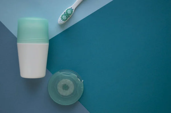 Mavi arka plan üzerinde yüz için kulaklar ve pedler için pamuk tomurcukları. Turkuaz renk, diş fırçası ve diş ipi kapağı ile bir deodorant