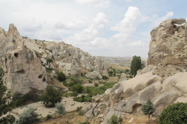 Csodálatos kilátás nyílik a sziklás dombok körül zöld fák híres úti cél - Cappadocia, Törökország — Stock Fotó