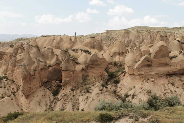 Gyönyörű háttér a sziklás táj Cappadocia, Törökország. Zöld bokrok és fű a hegyek között — Stock Fotó