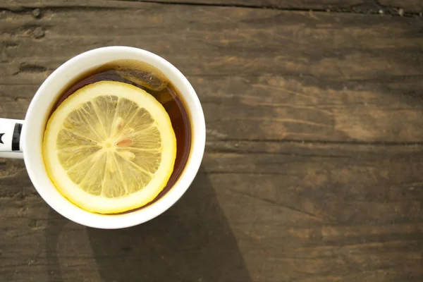 ahşap arka plan üzerinde üstte limonlu çay