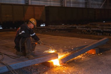 Fabrikadaki sanayi işçisi kaynaklarını kapatıyor.