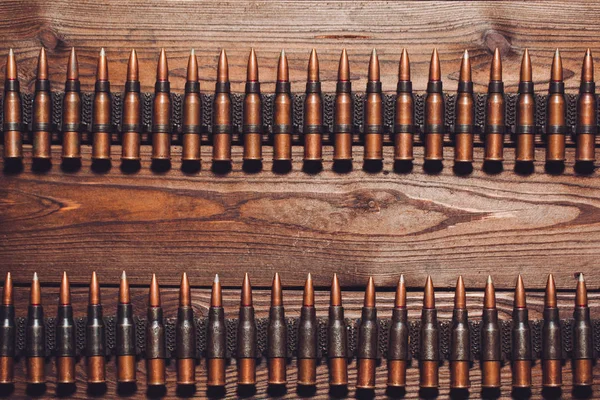 metal bullets in rows on wooden background